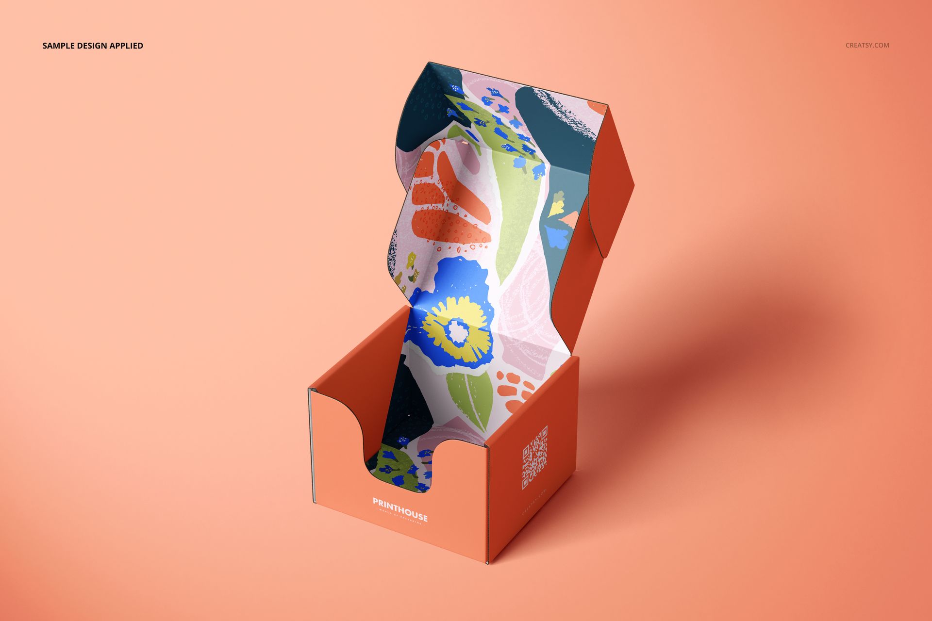 Front view of an open mailer box mockup with an orange exterior and colorful floral patterned interior on a peach background.