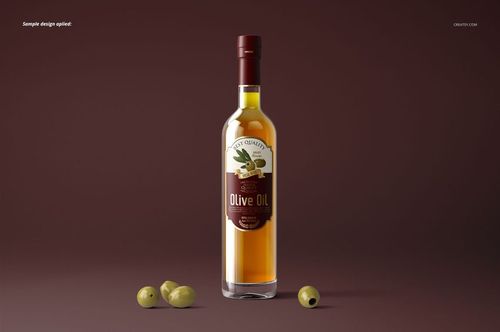Olive oil bottle mockup featuring a clear glass bottle, red label, and olives placed on a brown surface, front perspective.