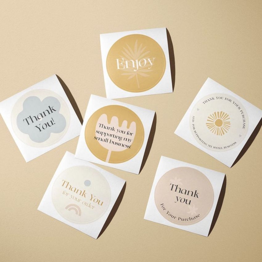 Sticker mockup showing six square sheets with round stickers in neutral tones, each featuring simple patterns and text.