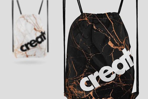 Front view of a drawstring bag mockup with black and copper marble design, large white lettering, and black strings.