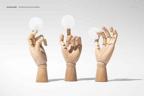 PSD mockup showing wooden hand models holding blank round stickers, set against a soft gray backdrop.