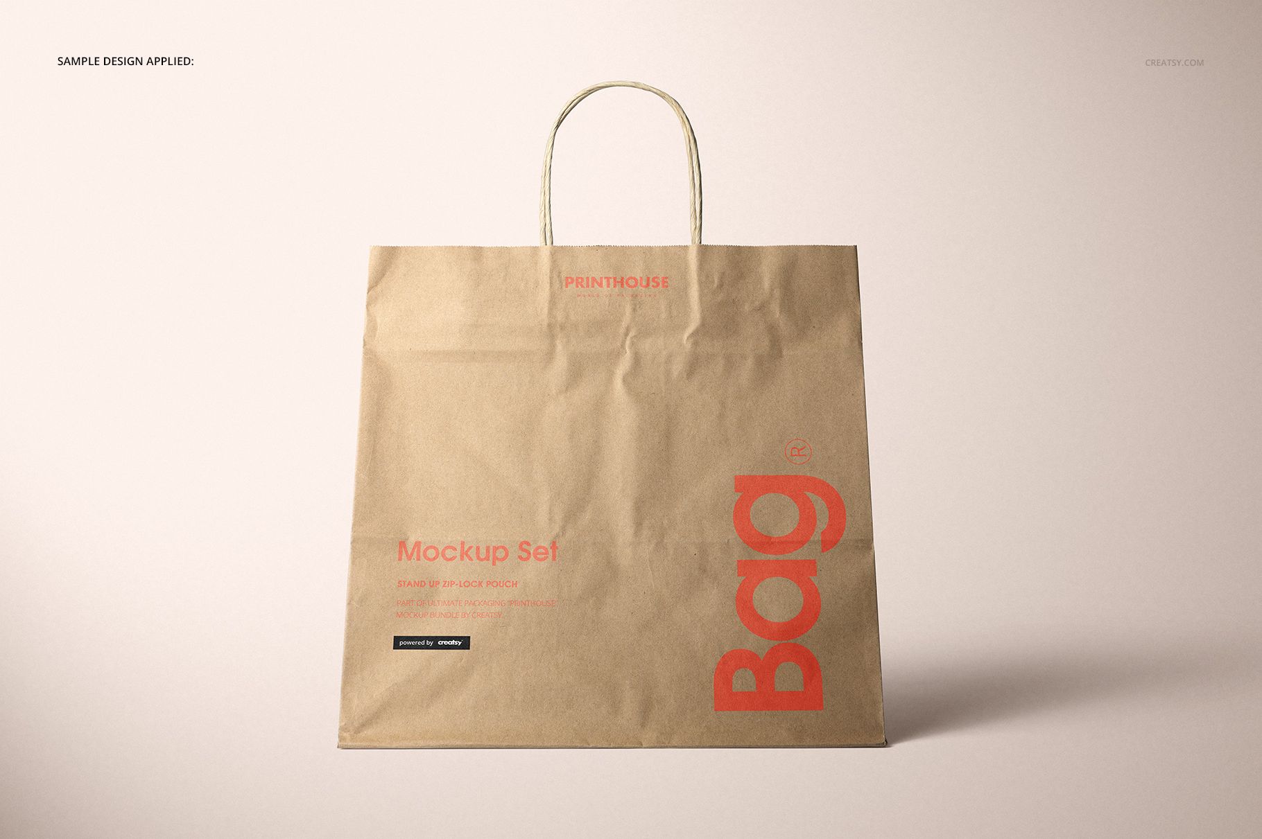 Natural kraft paper shopping bag mockup with red lettering, shown upright with handles against a light backdrop.