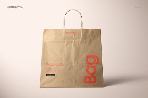 Natural kraft paper shopping bag mockup with red lettering, shown upright with handles against a light backdrop.