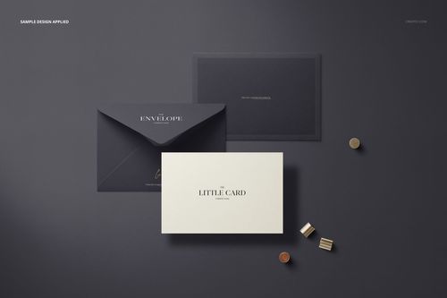 Stationery mockup with a black envelope and white card arranged side by side, shown from above with gold props nearby.