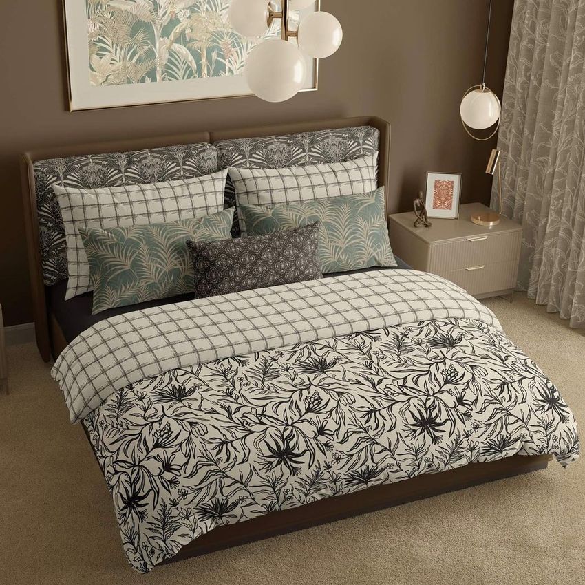 Bedroom scene bedding mockup showing a neatly made bed with patterned pillows and comforter in neutral and green tones.