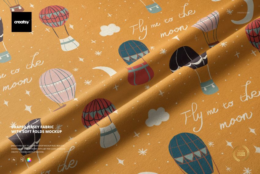 PSD mockup of jersey fabric with gentle folds, decorated with hot air balloons, clouds, and handwritten text.