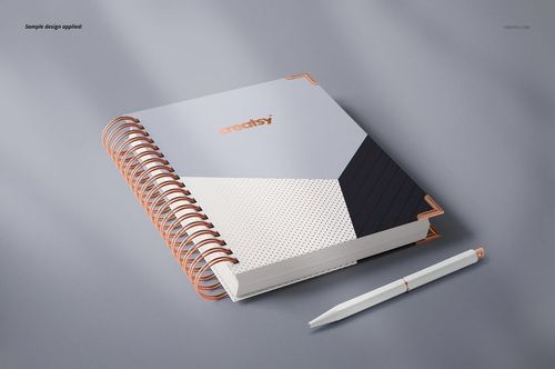 Spiral-bound planner mockup featuring a modern geometric cover in neutral tones, placed beside a matching pen.