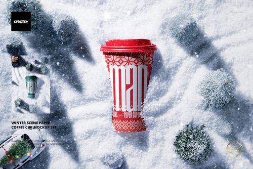 Winter scene PSD mockup featuring a paper coffee cup with red lid and festive design, surrounded by snowy foliage.