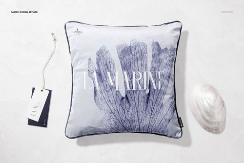 Front view of a square velvet cushion mockup with blue leaf pattern, dark edging, and a shell placed beside it.