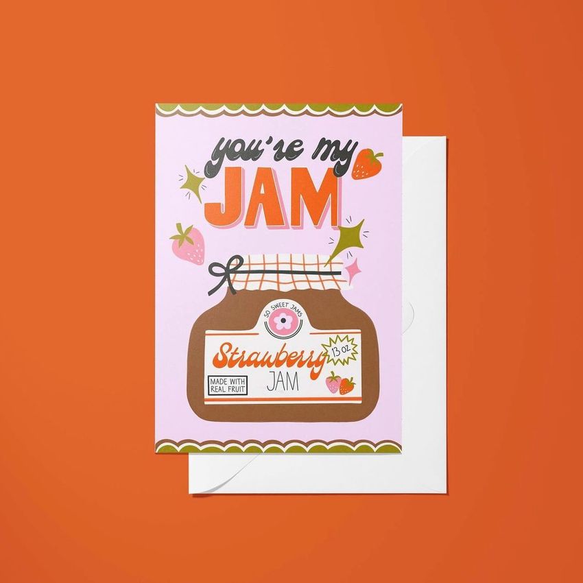 A5 card mockup featuring a greeting card with a playful strawberry jam jar illustration and colorful text on a pink background.