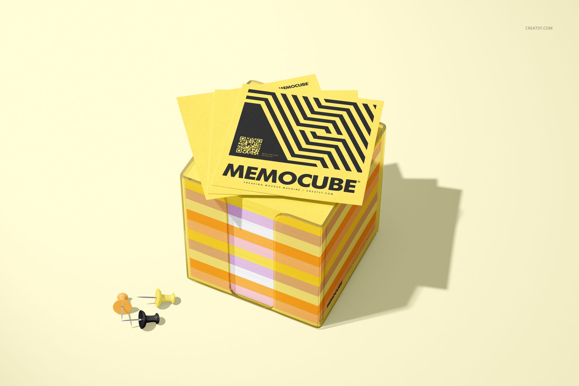 Yellow memo block cube mockup in an acrylic holder, with geometric patterned notes and assorted push pins nearby.