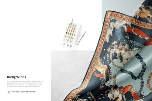 Close-up view of a silk scarf mockup with intricate multicolor patterns, shown on a light surface with paintbrushes nearby.