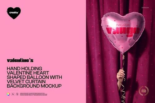 PSD mockup showing a person’s hand gripping a Valentine heart-shaped balloon in front of a pink velvet curtain backdrop.