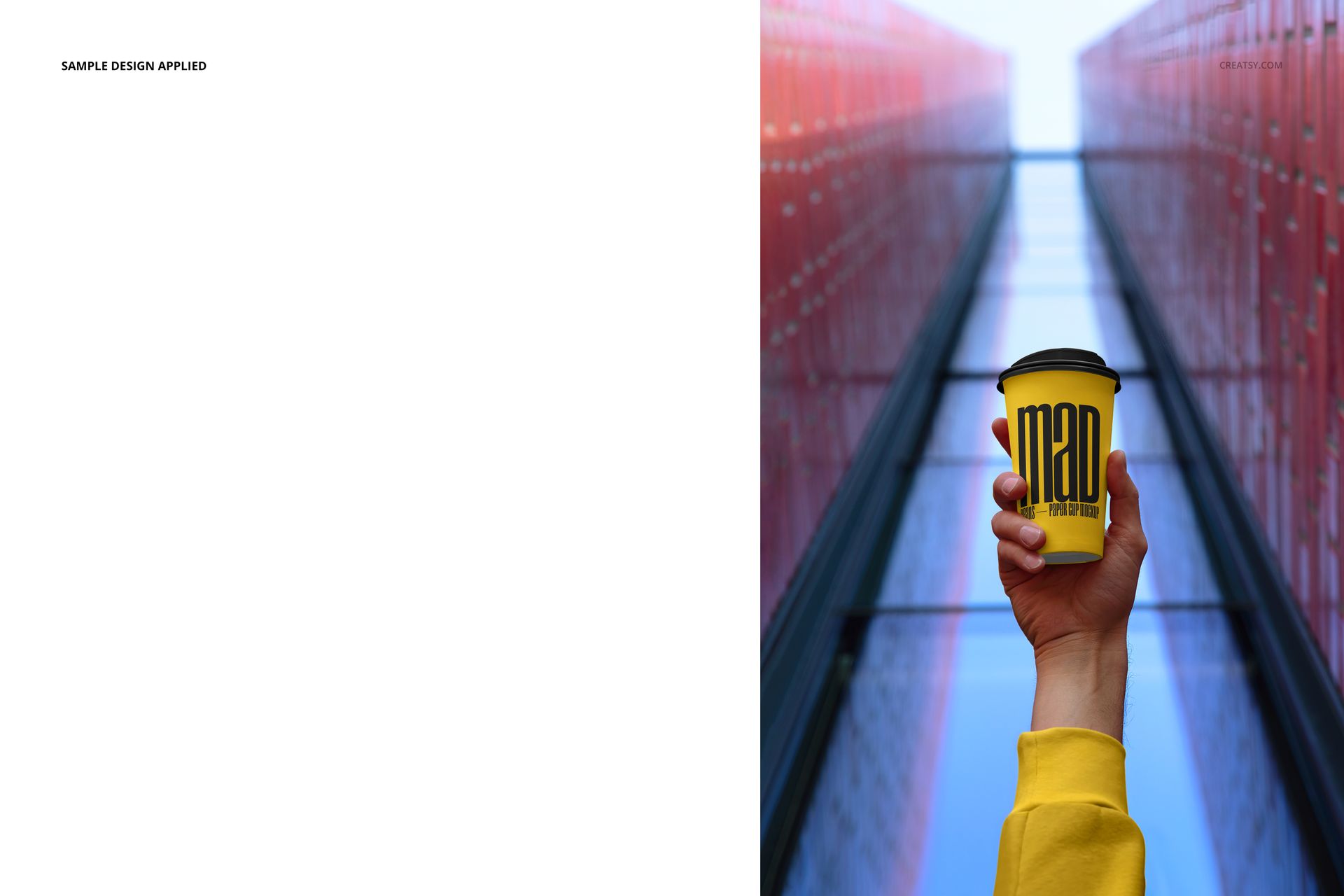 Yellow paper cup mockup with black lid, held up by a person in a yellow sleeve, set against modern city architecture.