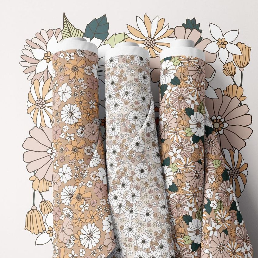 Fabric rolls mockup showing three upright rolls with floral patterns in beige, white, and brown tones on a light surface.