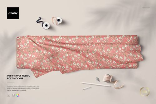 Top view of a fabric bolt mockup featuring a pink floral pattern, displayed on a light surface with sewing props nearby.