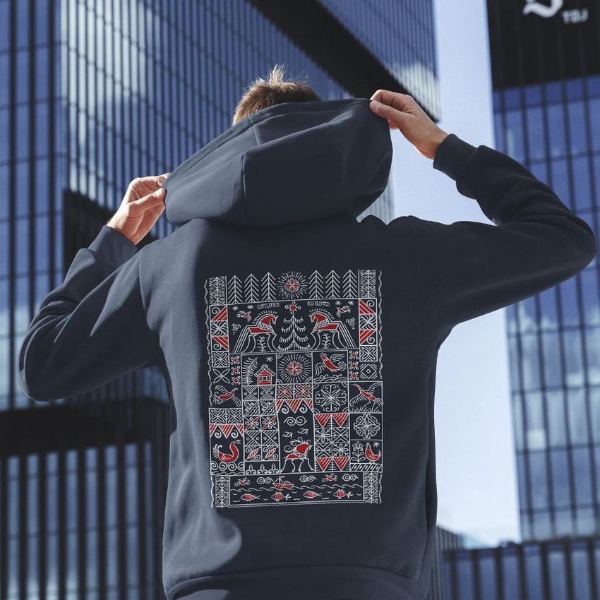 Person wearing an oversized hoodie mockup outdoors, showing a large geometric pattern in white and red on the back.