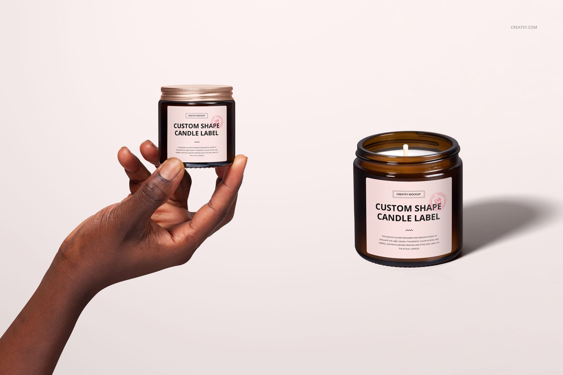 Amber jar candle mockup set showing one candle held by a hand and another placed on a light surface, both with cotton wicks.