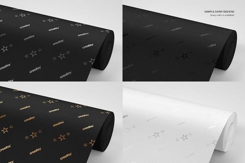 Mockup of wallpaper rolls in black and white, each with metallic star and text designs, shown from a side angle.