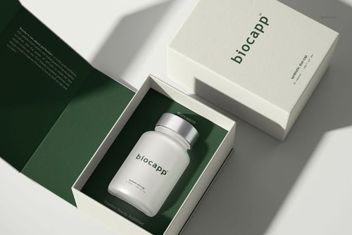 Cosmetics box packaging mockup featuring a frosted capsule bottle inside an open box with green interior lining.