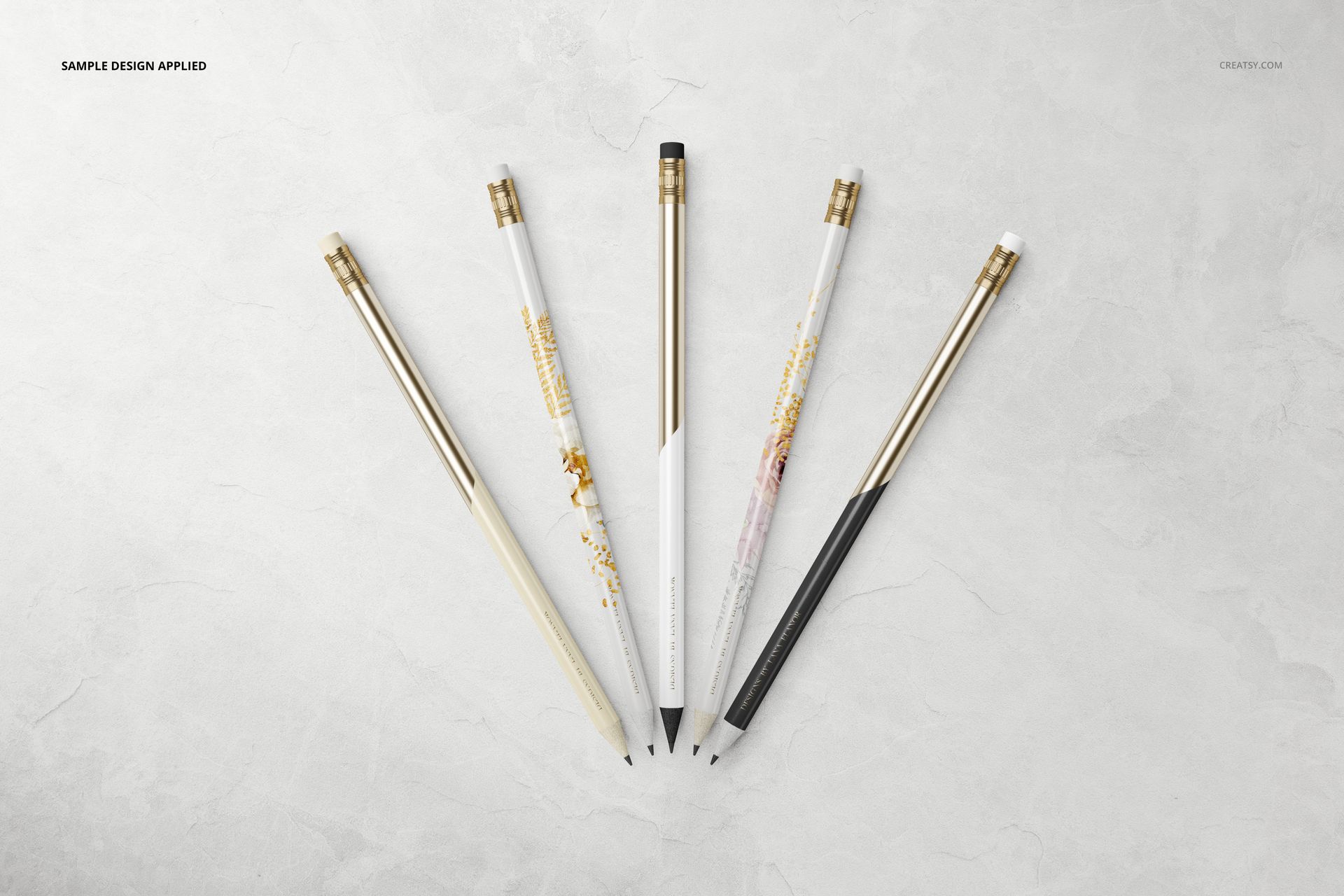 Stationery mockup featuring five pencils with metallic details, displayed in a spread on a marble-like background.