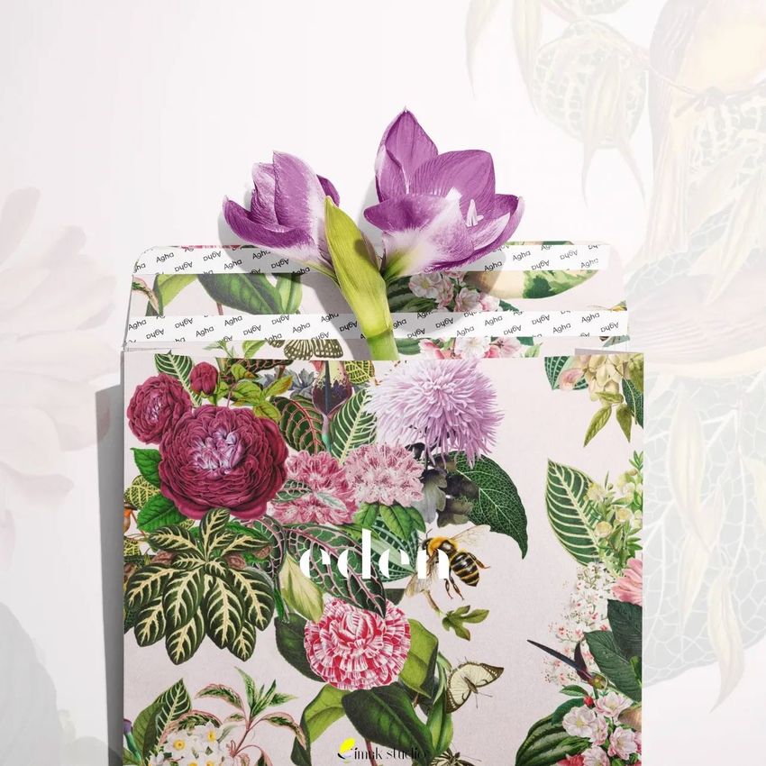 Kraft mailer mockup featuring a floral design with various colorful flowers and green leaves, topped with two purple flowers.