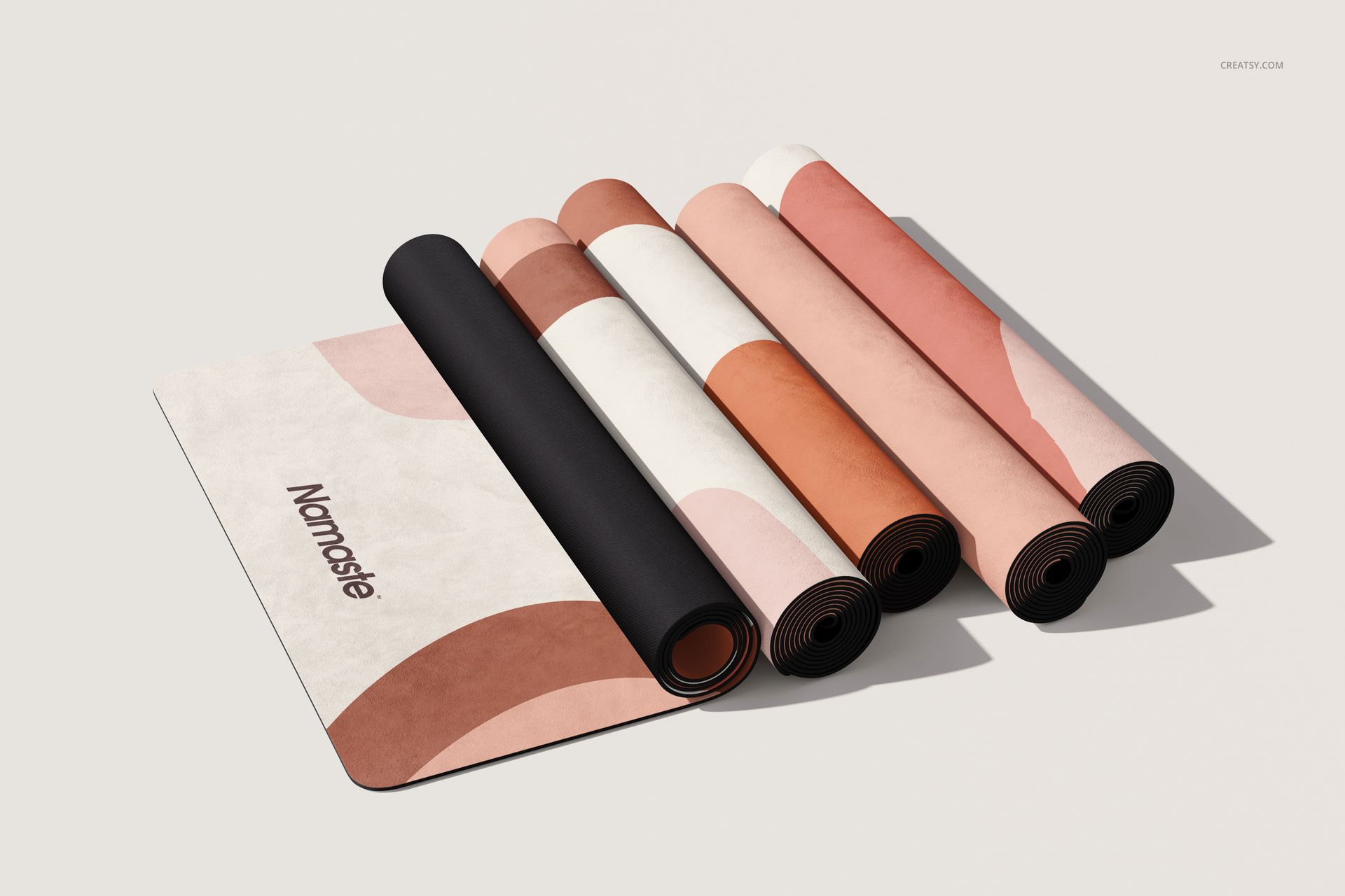PSD mockup showing multiple yoga mats with soft, modern patterns and a visible 'Namaste' text, arranged on a light surface.
