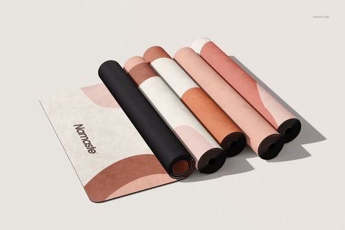 PSD mockup showing multiple yoga mats with soft, modern patterns and a visible 'Namaste' text, arranged on a light surface.