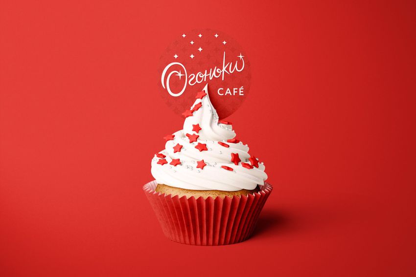 Cupcake toppers and wraps mockup featuring a cupcake with white frosting, red star sprinkles, and a red wrapper on a red background.