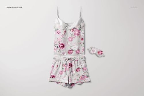 Short silk pajama mockup set displayed flat, showing a camisole, shorts, and sleep mask with pink and white floral design.