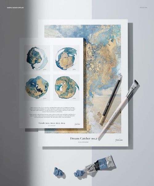 PSD mockup showing two art paper pads with watercolor-style patterns, paintbrushes, and painting accessories arranged around.
