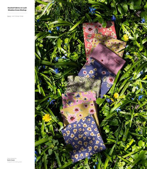 Outdoor scene showing six fabric samples with floral and leaf designs laid out on vibrant meadow grass, PSD mockup.