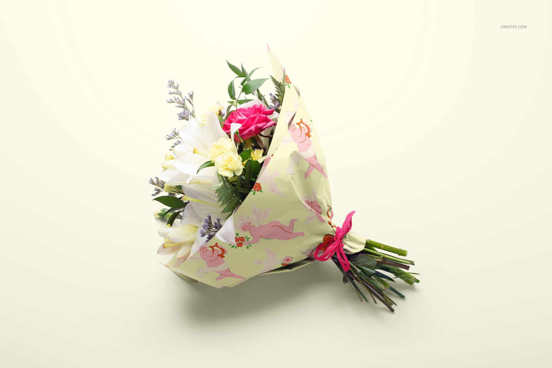 PSD mockup of colorful flowers in patterned wrapping paper, tied with a pink ribbon, placed against a cream backdrop.