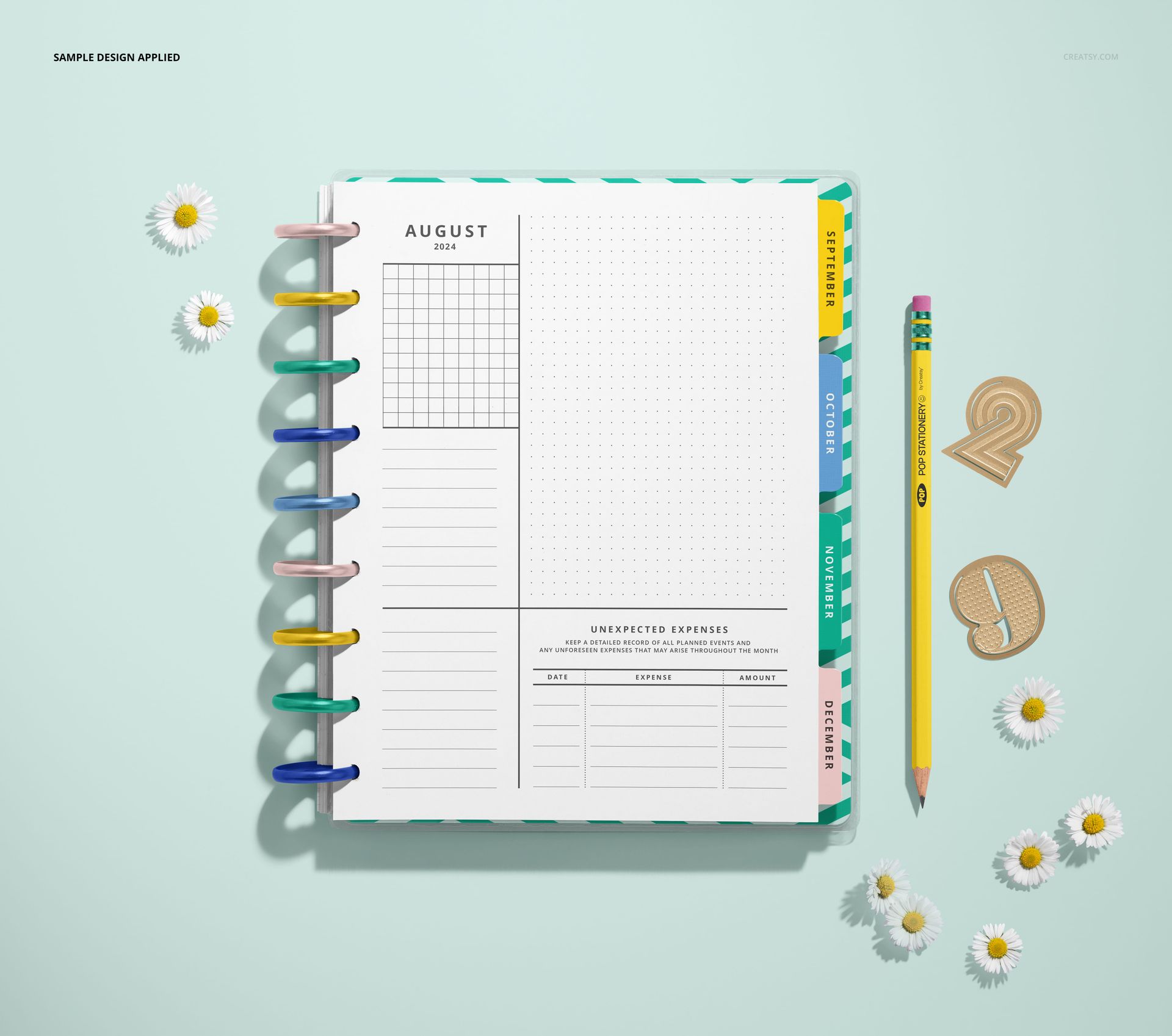 Top view of an open spiral planner mockup featuring patterned dividers, a pencil, and decorative daisies on a pastel background.