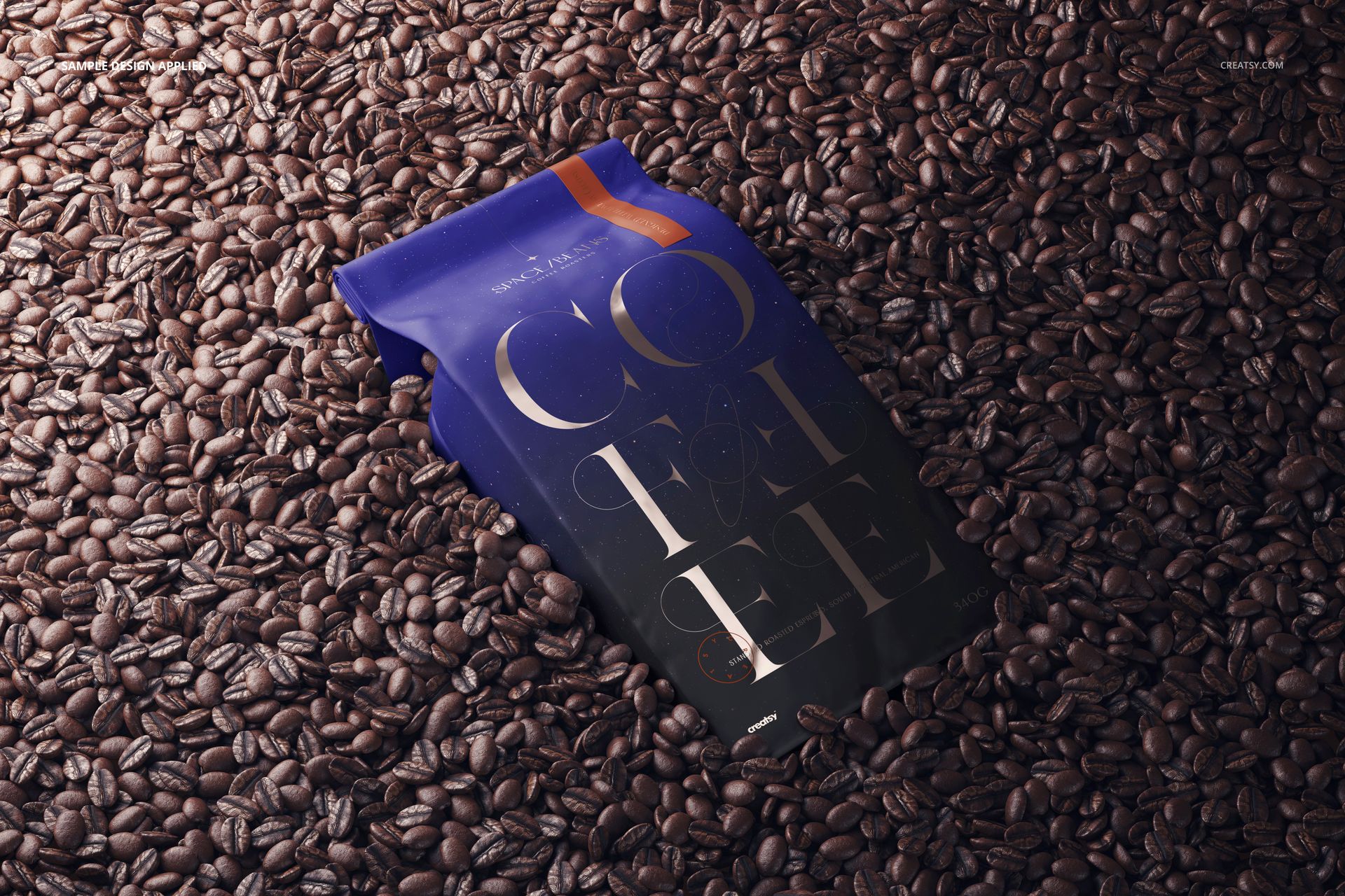 Matte coffee bag mockup lying on a surface covered with roasted coffee beans, shown from a top view.