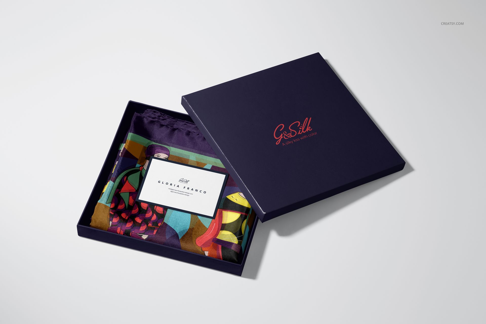 Colorful habotai silk scarf mockup in a navy box, featuring multicolored design and visible branding on the lid.