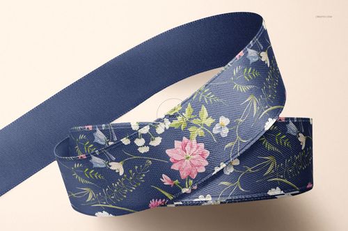 PSD mockup of a blue ribbon with detailed botanical designs, displayed on a light background in a close-up view.