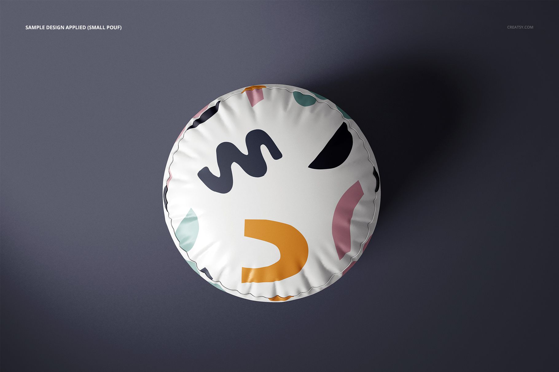 Small round pouf mockup featuring multicolored geometric shapes, top-down perspective against a plain dark surface.
