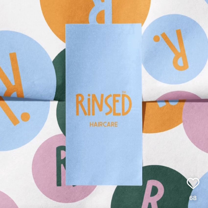 Sticker mockup showing a blue rectangular card with gold text on top of colorful circular stickers featuring bold letters.