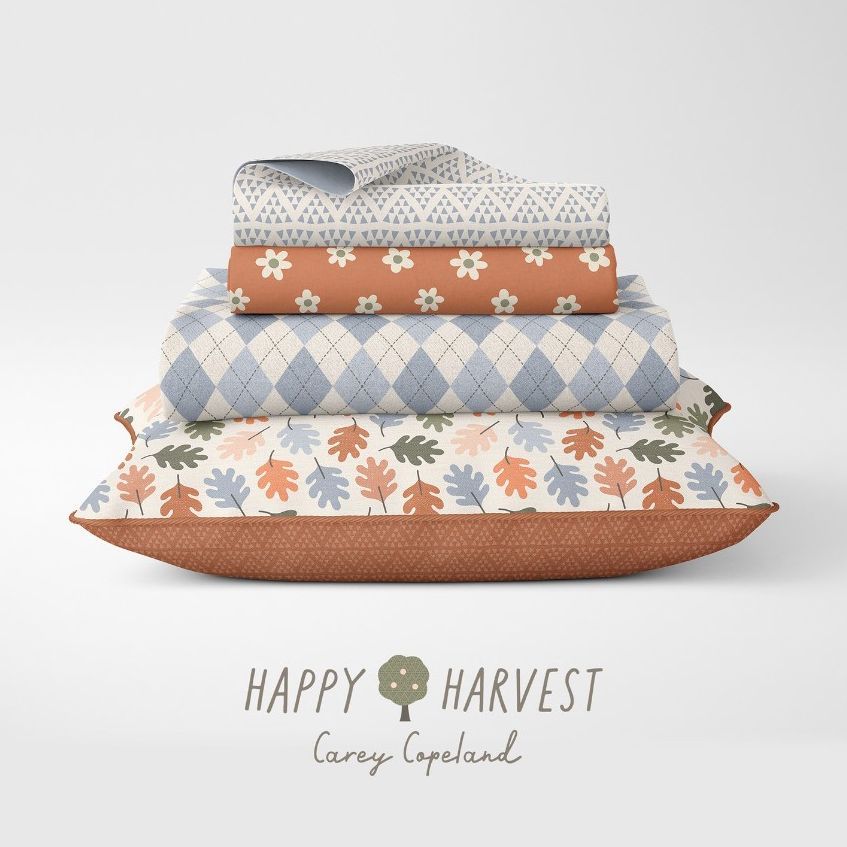 Stacked pillowcases and a blanket mockup with seasonal patterns in muted orange, blue, and beige, set against a plain backdrop.