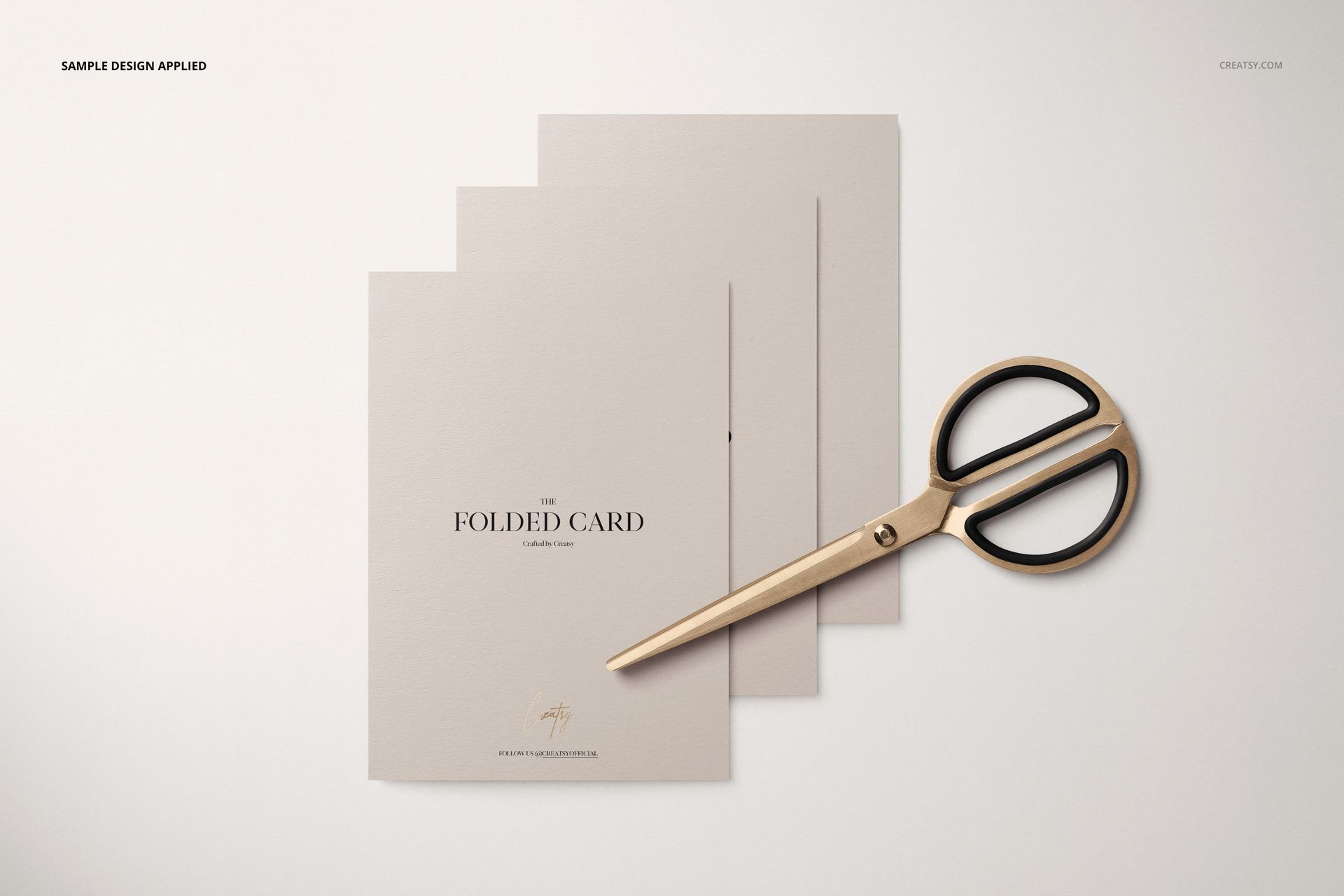 Folded card mockup set with three light beige cards arranged in a row, gold scissors placed on the right side.