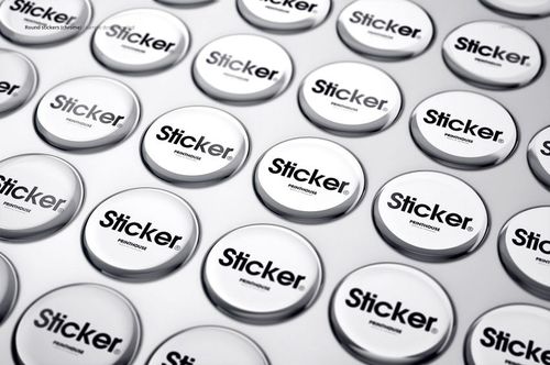 PSD mockup showing several shiny round stickers with black text, organized in rows on a pale background.