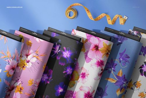 Fabric bolts mockup showing colorful flower designs on different textiles, viewed from above with a measuring tape nearby.