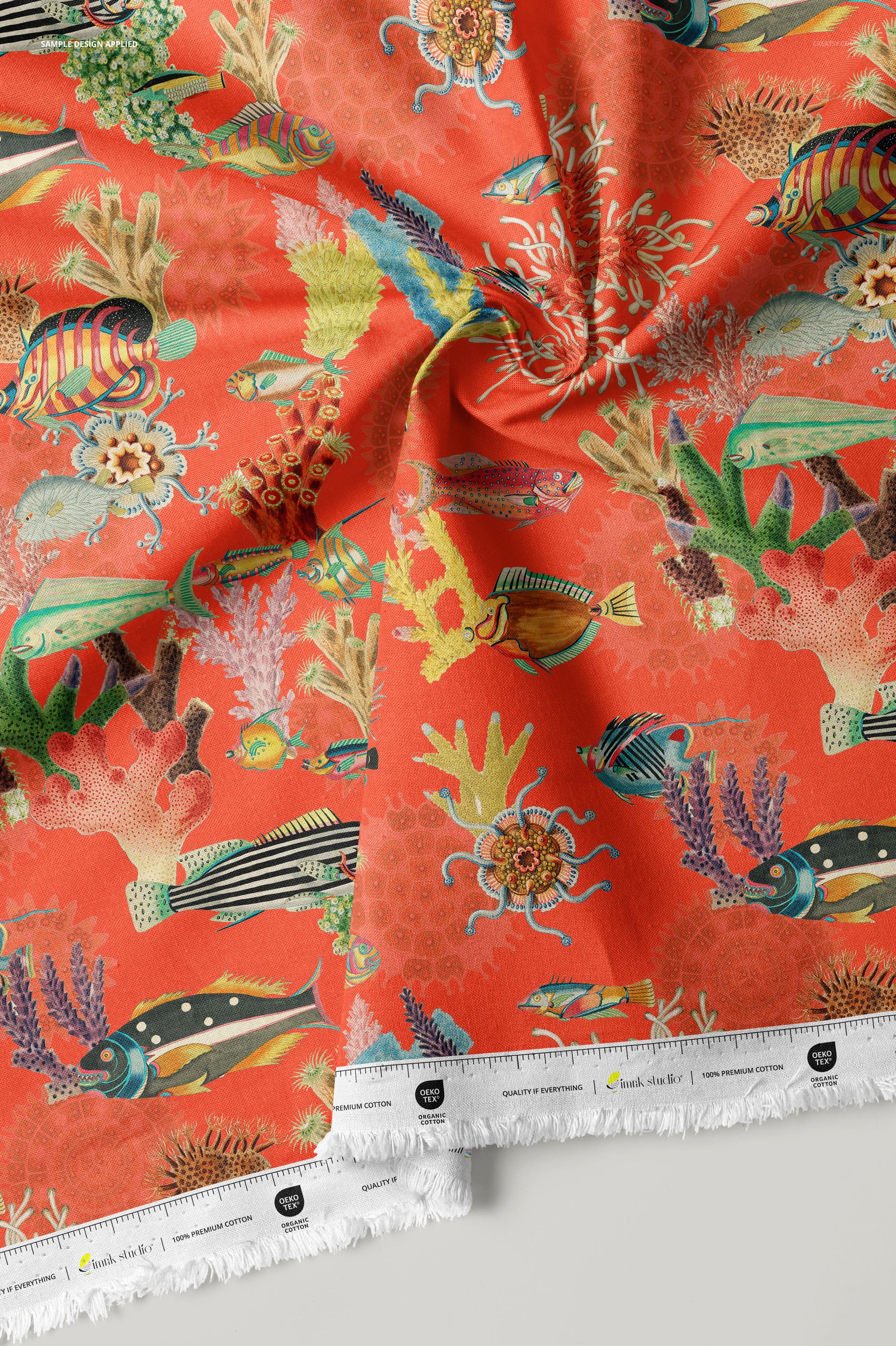 Close-up of cotton fabric mockup with colorful marine life and coral illustrations on an orange surface.