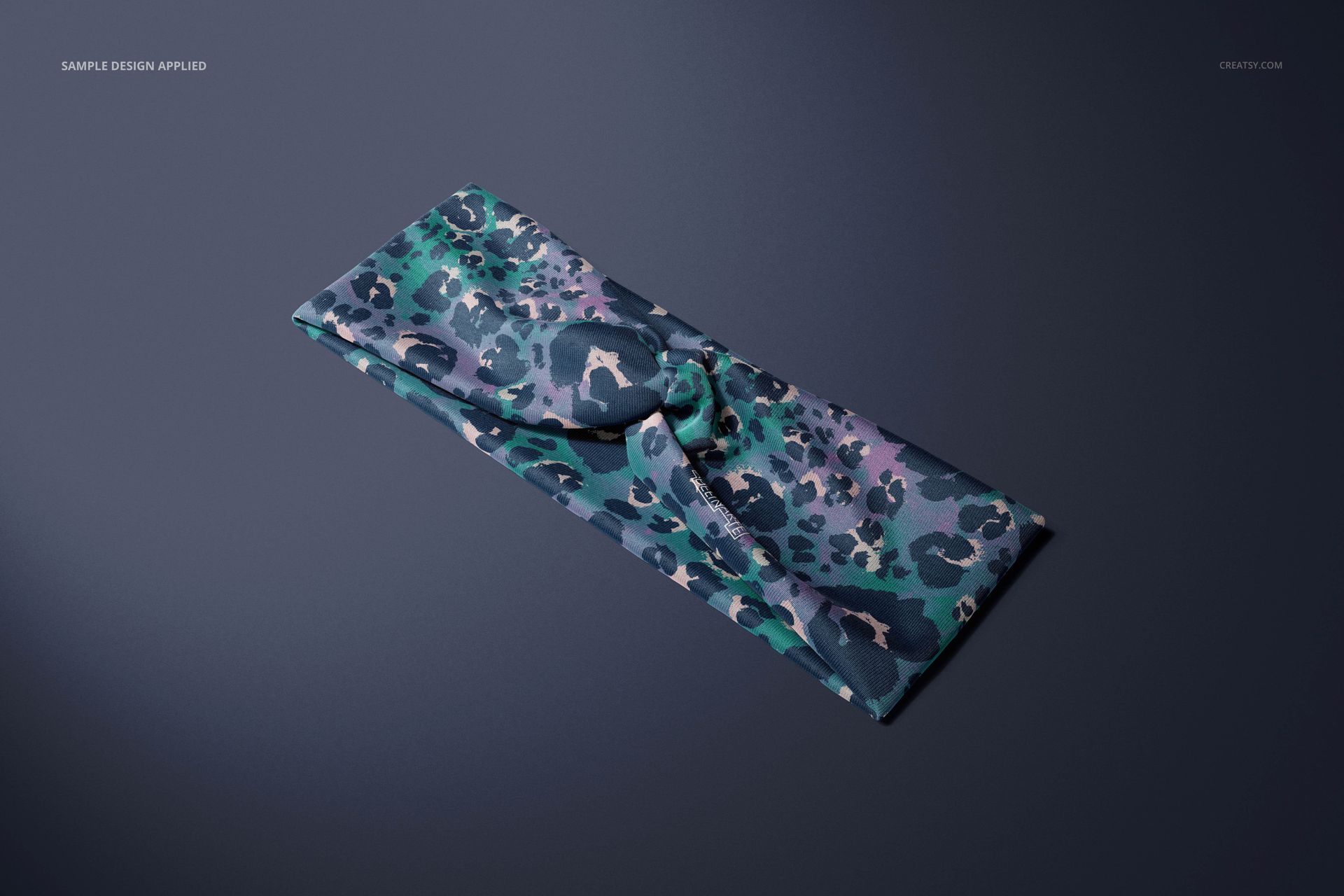 Faux knot headband mockup with a bold animal print in teal and navy tones, displayed in a top view on a plain background.
