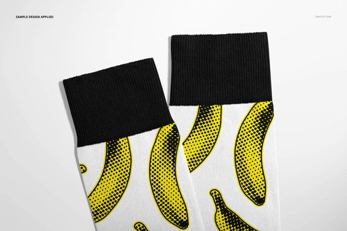 High cuff socks mockup with black ribbed cuffs and white fabric decorated with yellow banana graphics, flat lay style.