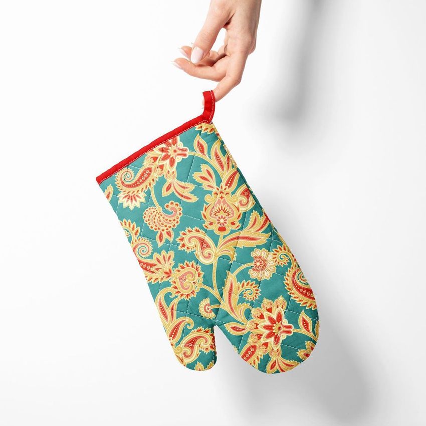 Oven mitt mockup featuring a hand holding a mitt with a colorful paisley pattern on a teal background, viewed from above.