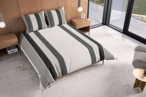 Mockup scene showing a neatly made bed with gray and white striped comforter, wooden furniture, and large windows.