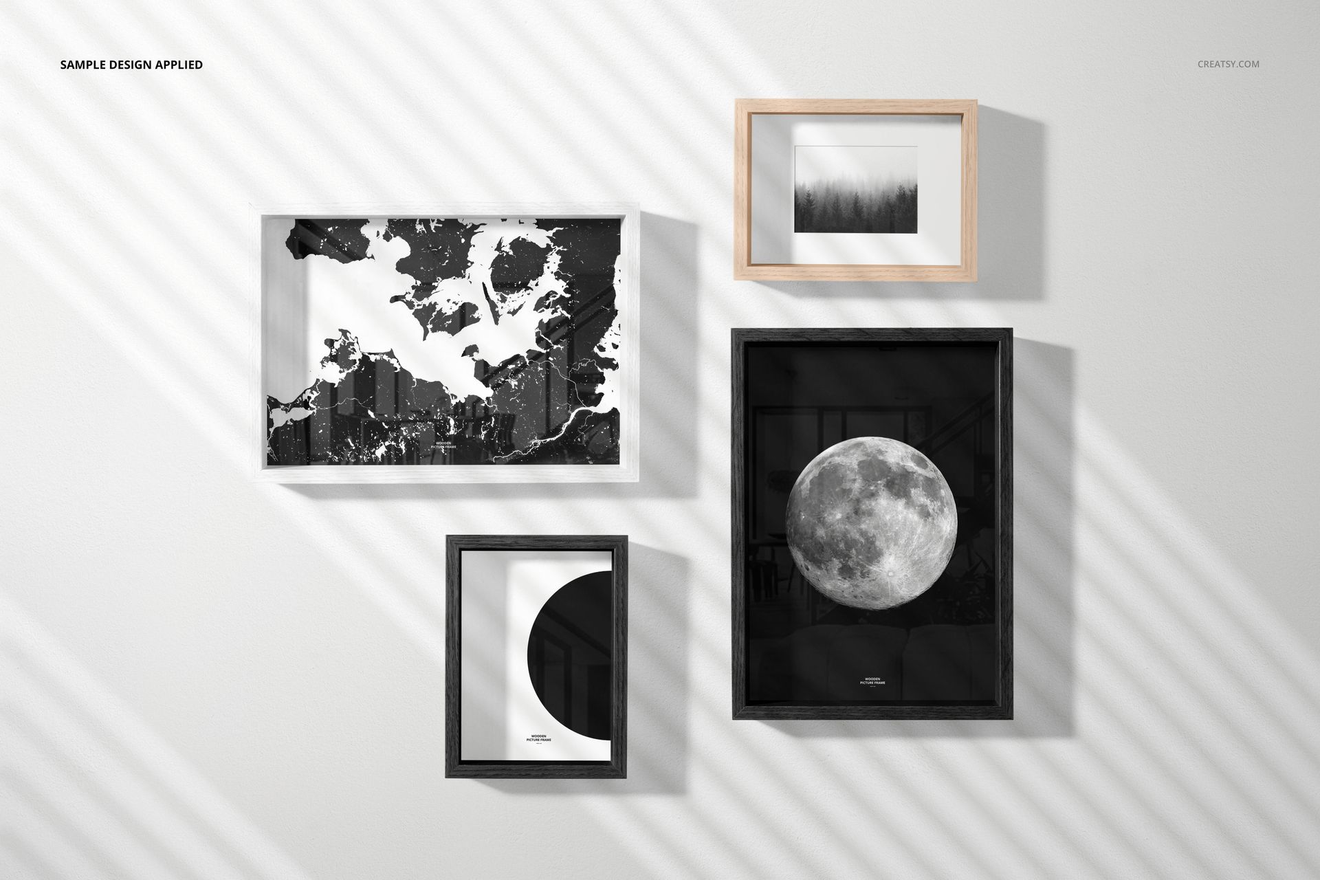 Wooden picture frame mockup featuring various frame styles and grayscale art prints, shown from a front view on a wall.
