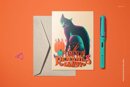 Halloween-themed 5x7 card mockup with a black cat, pumpkin, and colorful pen, displayed with an open envelope.